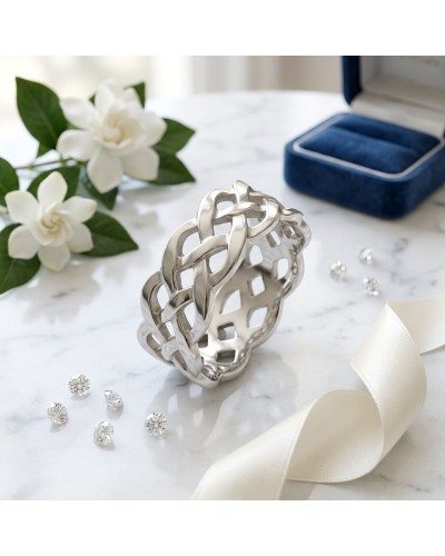 Alliance TRESSE en or: bracelet argenté à maillage tressé, posé sur marbre avec fleurs blanches et boîte jewelry bleu à l’arrièr