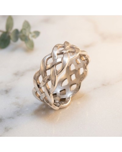 Alliance TRESSE en or: bague argentée à motifs tressés détaillés sur fond marbré, vue rapprochée.