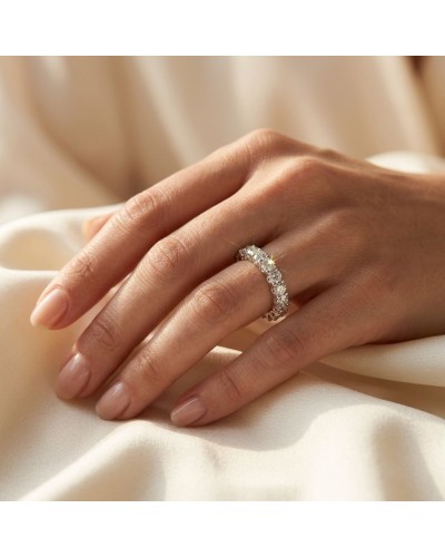 Alliance en or tour complet ornée de 19 diamants sur le doigt, brillant sur fond satin beige.