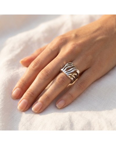 Alliance ATIANA femme en or : bague moderne argentée avec motifs ondulés portée sur le doigt.