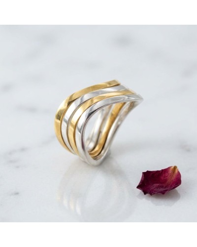 Alliance SERPENTINE bicolore en or: bague torsadée en or jaune et argent, posé sur marbre avec pétale rouge.