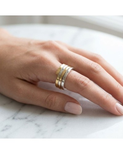 Alliance entrelacée bicolore femme en or sur doigt, bague au design à 4 anneaux dorés et argentés.