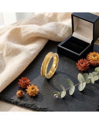 Alliance incurvée et sablée homme en or, bijou élégant posé sur une surface sombre avec boîte à bijoux et fleurs d’automne.