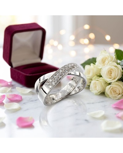 Alliance inséparable: bague en or argenté sertie de diamants sur fond de coffret et roses blanches.
