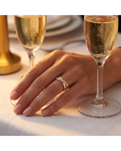 Alliance Inséparable 20 diamants femme en or: main féminine portant une bague dorée avec diamants près de flûtes à champagne sur