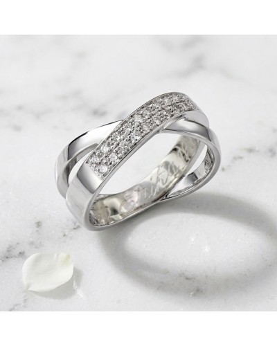 Alliance en or blanc sertie de 20 diamants pour femme, bague moderne croisée sur fond marbre.