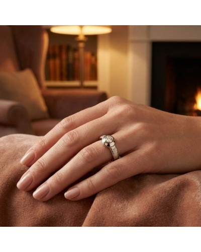 Alliance STARSKY en or avec diamant serti sur doigt posé sur une couverture, ambiance cheminée et salon chic.