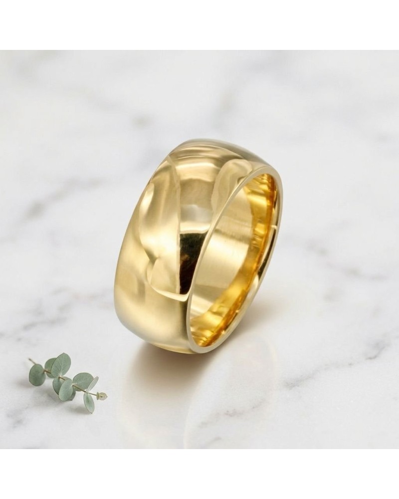 Alliance large bombée femme en or jaune Ferré, bague contemporaine, détail brillant sur marbre blanc.