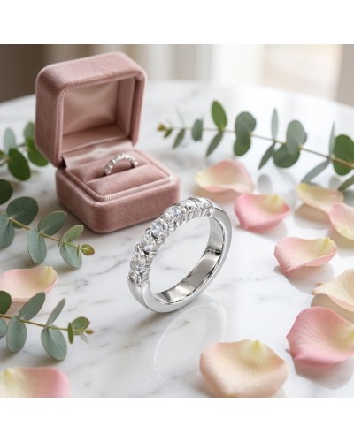 Alliance baguette sertie de 7 diamants en or blanc, élégante sur marble avec boîte rose et pétales.