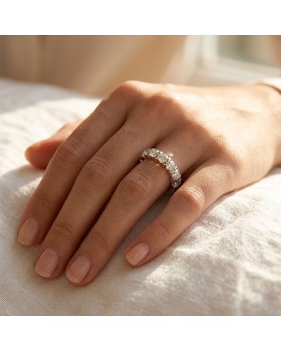 Alliance baguette sertie de 7 diamants femme en or sur doigt nu, proche pris en lumière.