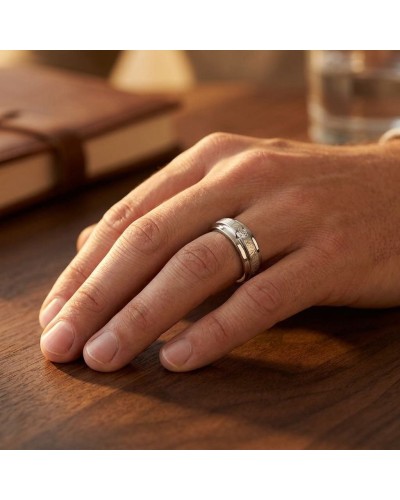 Alliance homme en or sertie d'un diamant, visible sur le doigt posé sur une table en bois.