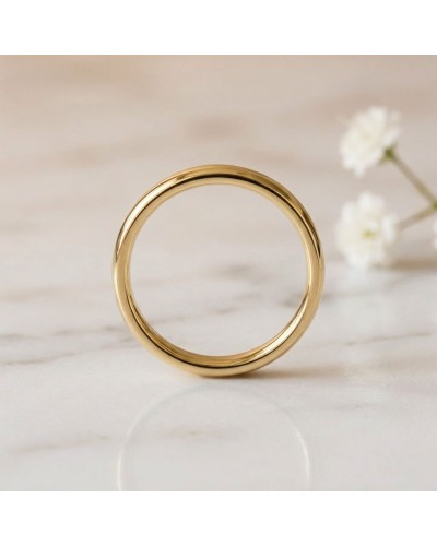 Alliance bombée fine pour homme en or jaune, premier plan sur bague lisse et brillannte sur fond clair.