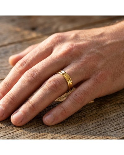Alliance moyenne bombée pour homme en or porté sur le dos de la main, premier plan sur le doigt et la bague dorée.