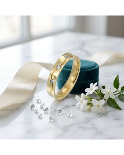 Alliance avec vague gravée et 3 diamants femme en or jaune, présentée sur plateau turquoise avec ruban et fleurs blanches.