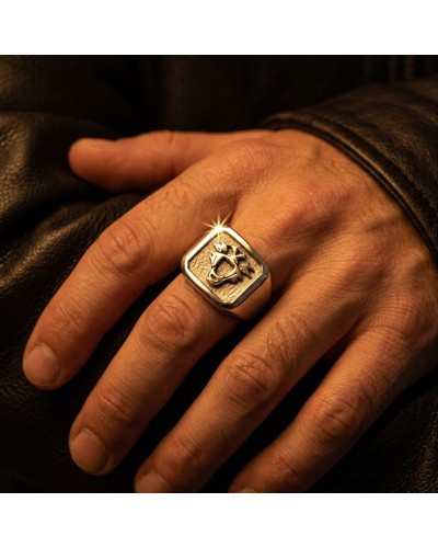 Chevalière argent massif rhodié 925/1000 sur doigt, logo gravé au centre et éclat métallique.