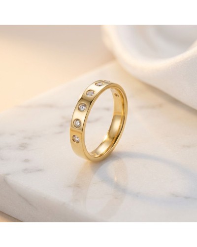 Alliance demi-empierrée en or femme avec diamants sur fond marbré, doré et élégant.