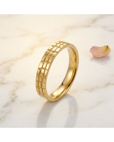 Alliance demi-effet crocodile femme en or, bague dorée au motif texturé sur fond clair.