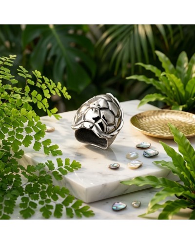 Bague TORTUE argentée avec motif écaille posé sur socle marbré, entourée de feuilles et perles nacrées.