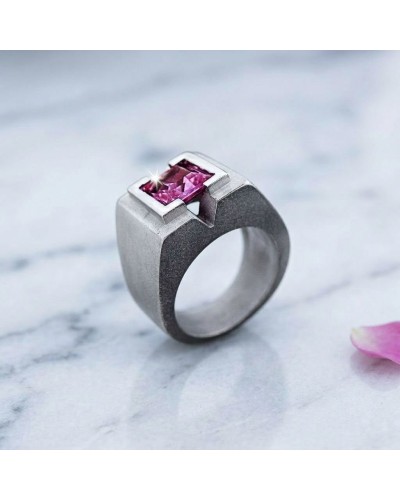 Bague MASA DEPAN en métal argenté avec pierre centrale rose fuchsia rectangulaire, dessin moderne et angle cubic, sur fond marbr
